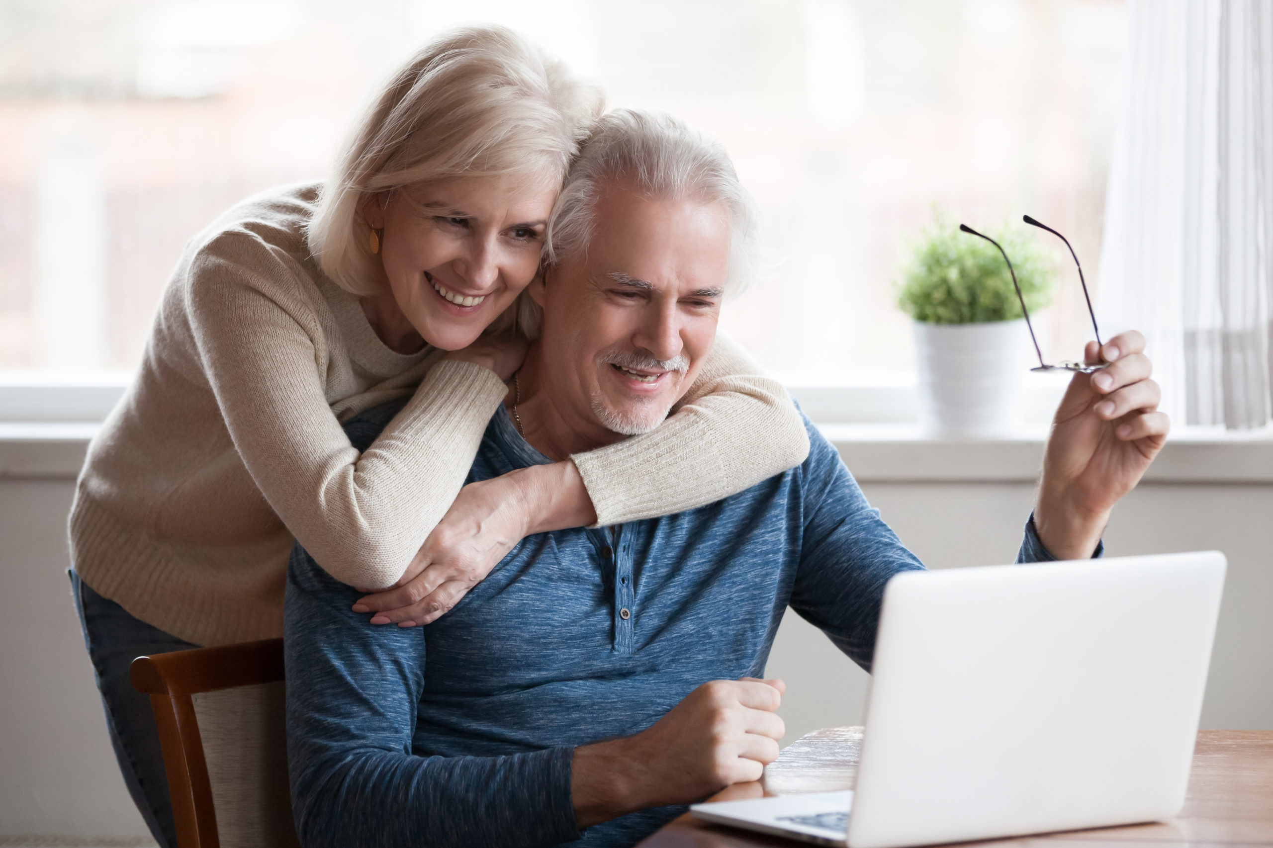happy senior couple looking at laptop