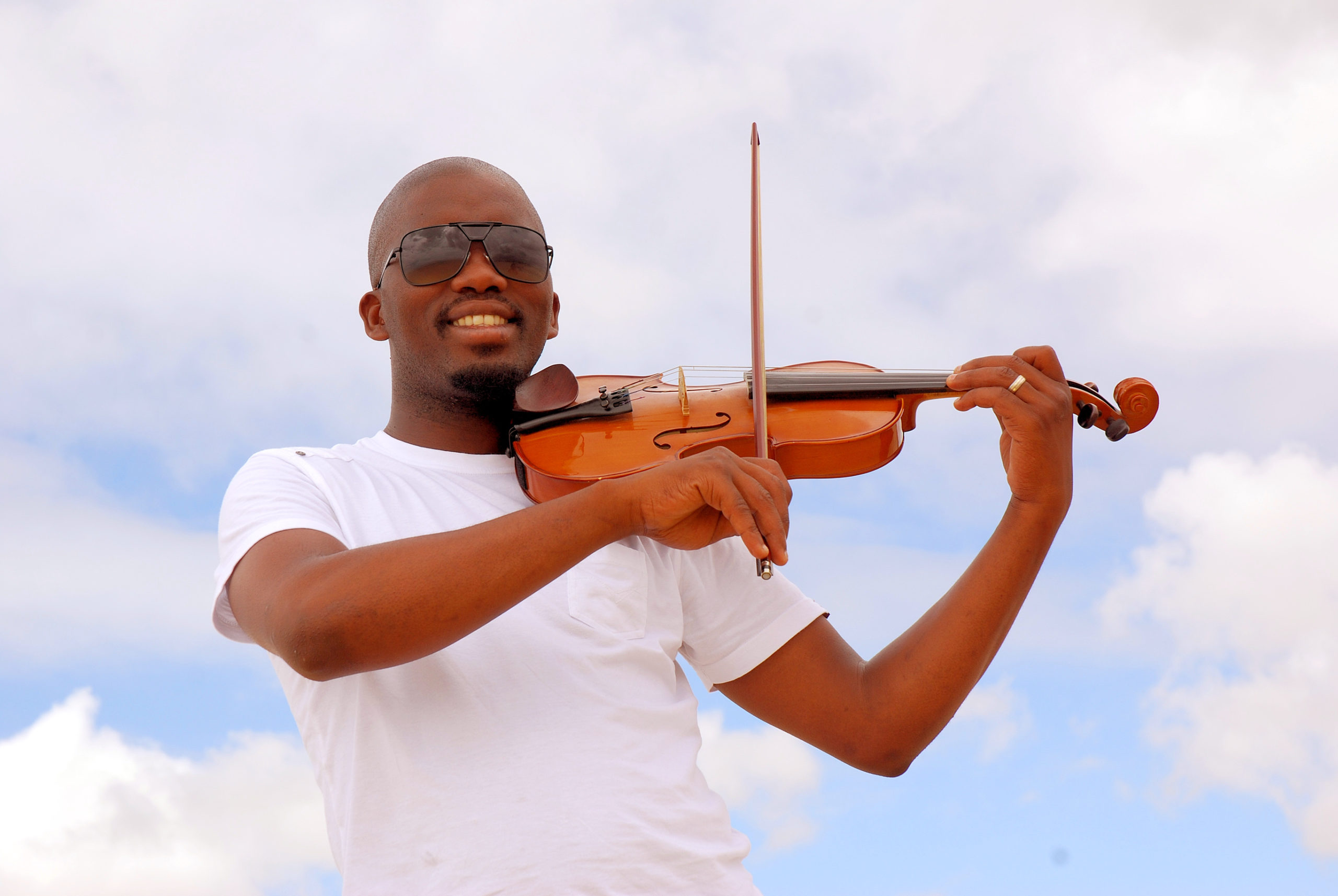 young african american playing violin outside wearing sunglasses