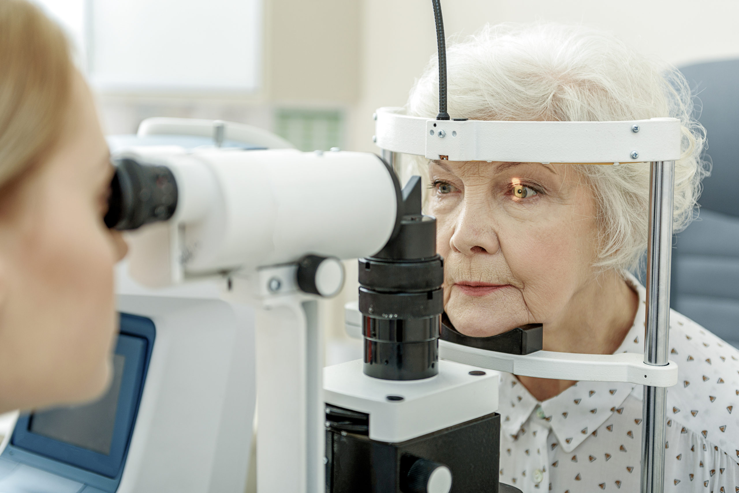 eye doctor examining senior woman's eye