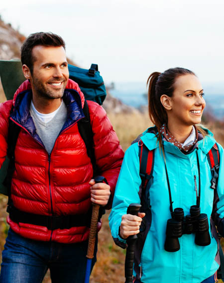 Young couple in windbreakers hiking