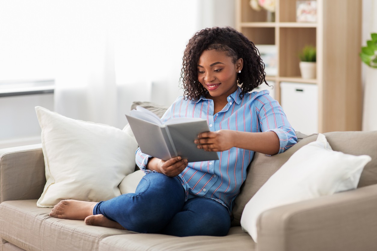 african-american-woman-reading-on-sofa